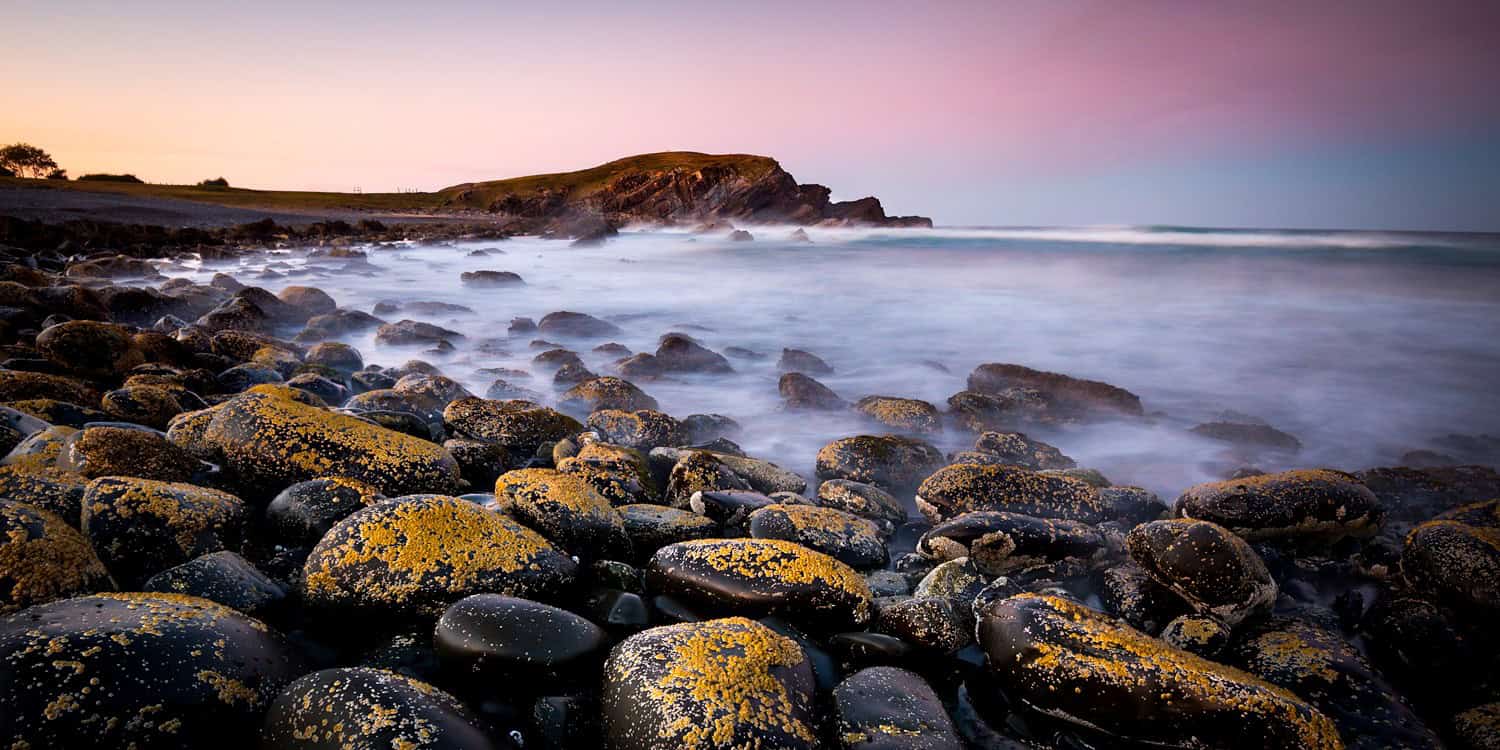 Pebbly shoreline at Crescent Head New South Wales Australia with gentle waves washing over stones fine art print