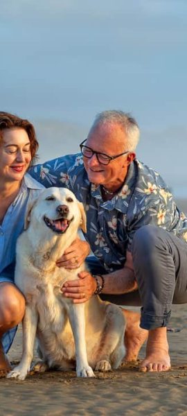 Family sitting with their dog on beach