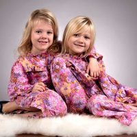 Two daughters smiling and enjoying a happy moment together