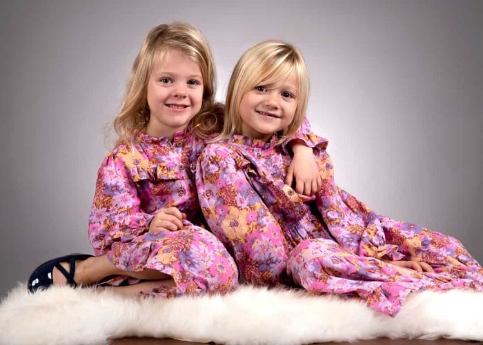 Two daughters smiling and enjoying a happy moment together