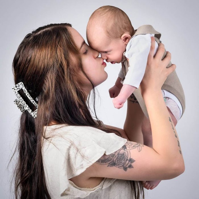 Mother kissing her newborn baby