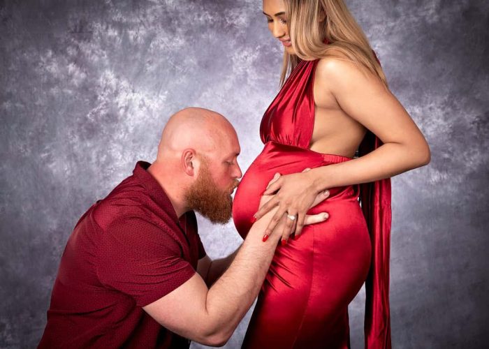 Husband kissing his wife’s pregnant belly