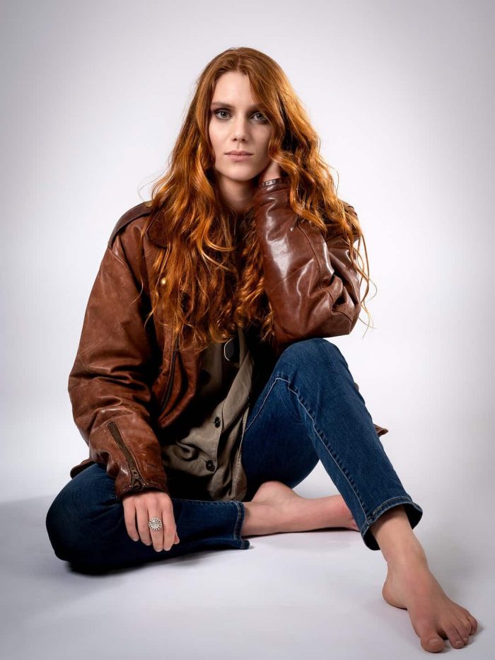 Studio portrait of a red-haired model seated