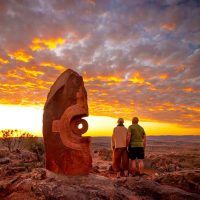 Colourful sunset at Broken Hill with tourists watching near hilltop monuments, lifestyle travel photography