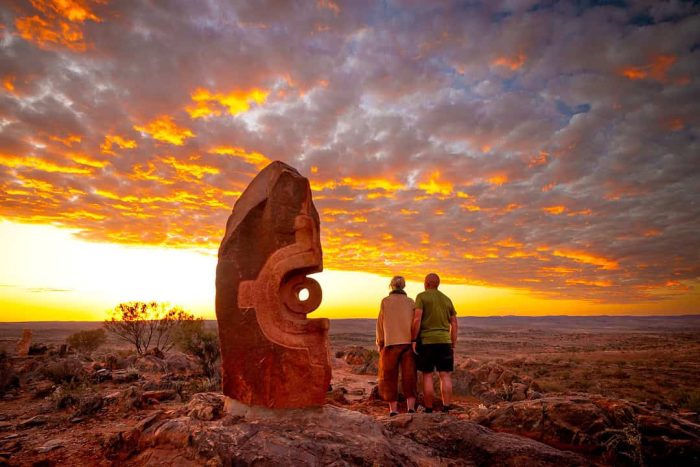 Colourful sunset at Broken Hill with tourists watching near hilltop monuments, lifestyle travel photography