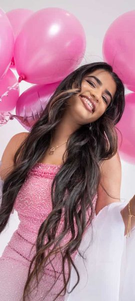 Studio portrait of girl celebrating birthday with pink balloons, laughing and smiling, lifestyle photography