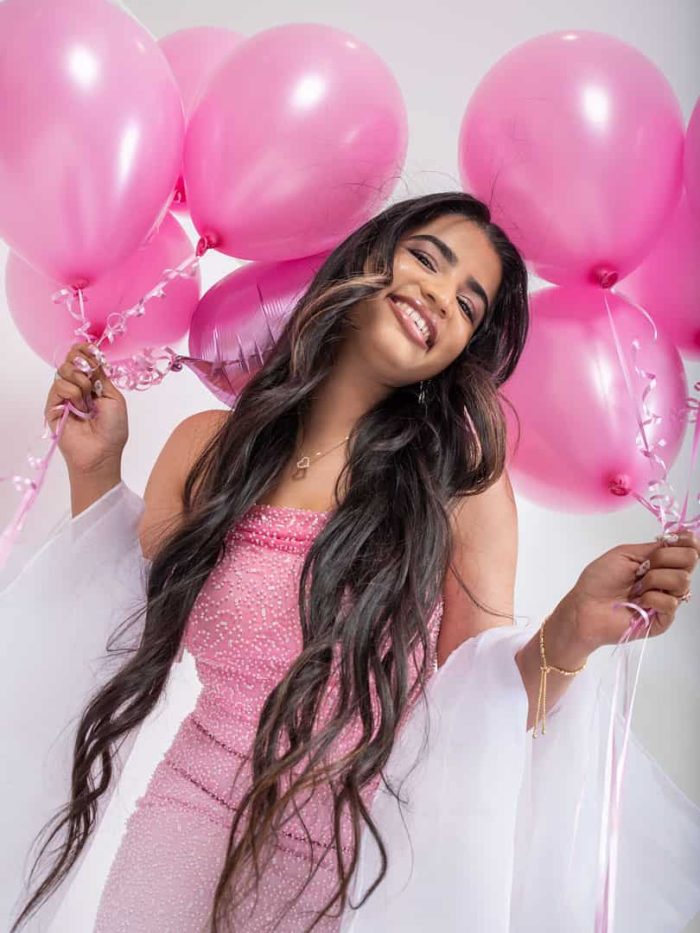 Studio portrait of girl celebrating birthday with pink balloons, laughing and smiling, lifestyle photography