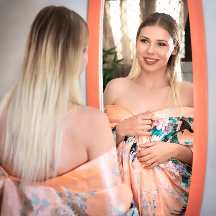 Woman preparing for a spray tan while looking in a mirror during a commercial photoshoot