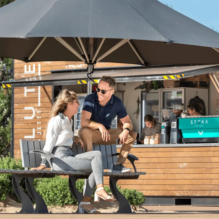Business professionals talking over coffee at an outdoor cafe during a photoshoot