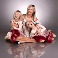 Mother and daughters laughing together in a studio