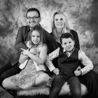 Black-and-white studio portrait of happy parents with two children