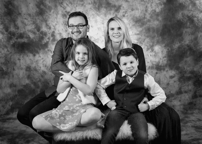 Black-and-white studio portrait of happy parents with two children