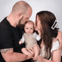 Happy couple kissing their newborn baby