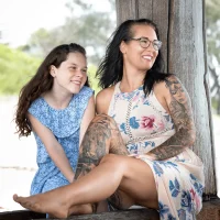 Mother and daughter sitting happily under Coffs Jetty