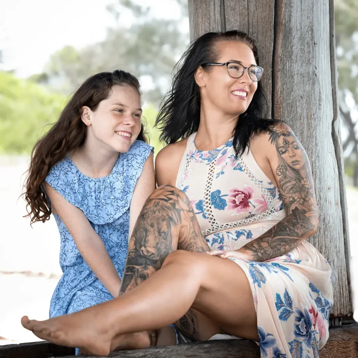 Mother and daughter sitting happily under Coffs Jetty