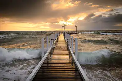 Coffs Harbour jetty at sunset with reflections on the water