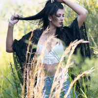 Lady standing in a field surrounded by natural scenery