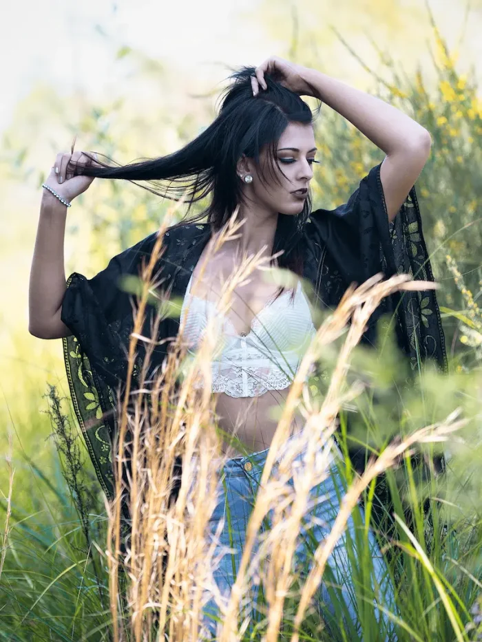 Lady standing in a field surrounded by natural scenery
