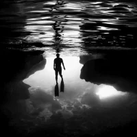 Silhouette of a diver at the entrance of an underwater cave