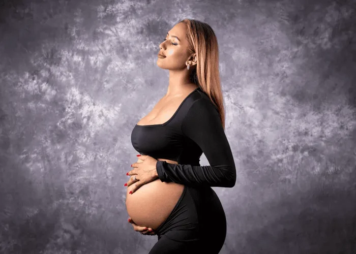 Pregnant woman posing for a maternity portrait in a studio