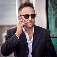 Commercial portrait of a man wearing glasses while answering a mobile phone