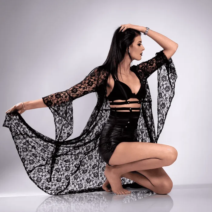Studio portrait of a woman posing in a lacy black outfit